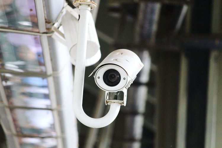Low angle view of white surveillance camera
