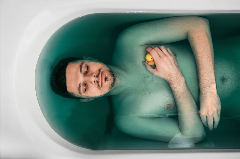 Directly above shot of shirtless man in bathtub