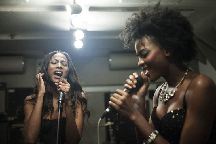 Young women singing in a recording studio