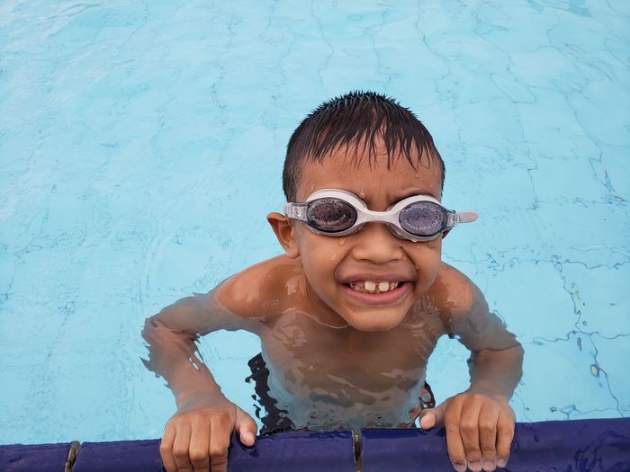 High angle portrait of smiling boy in swimming pool