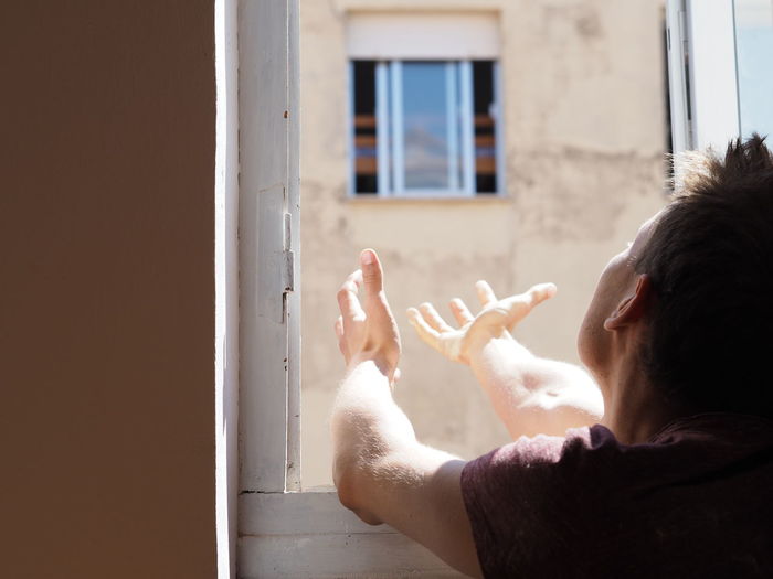 Man looking up from window in distress