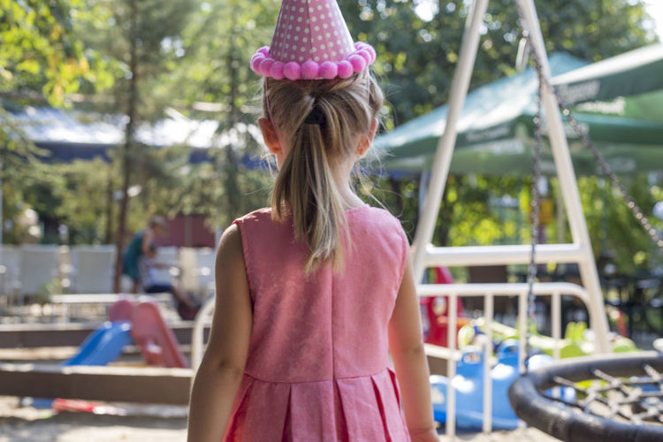 Rear view of girl standing at playground
