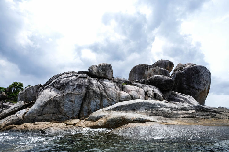 Rocks in sea against sky