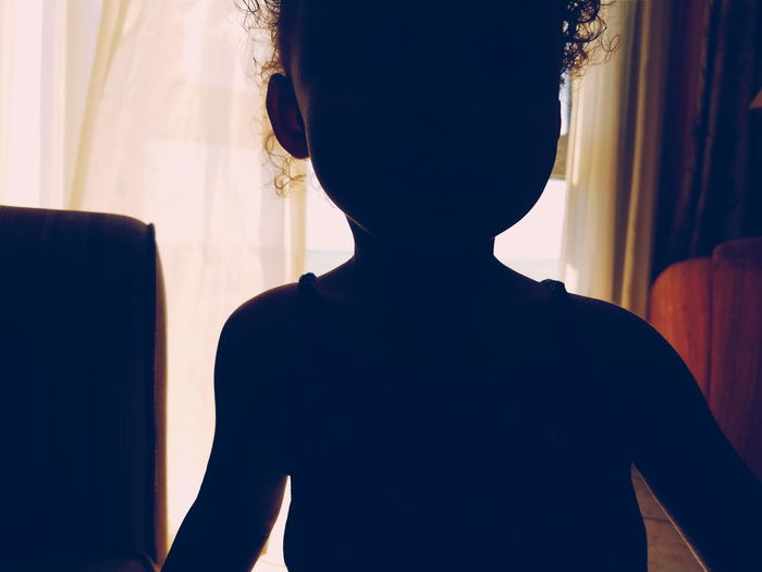Silhouette of baby standing at room