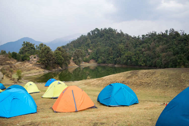 Scenic view of tent on mountain against sky at deoria tal