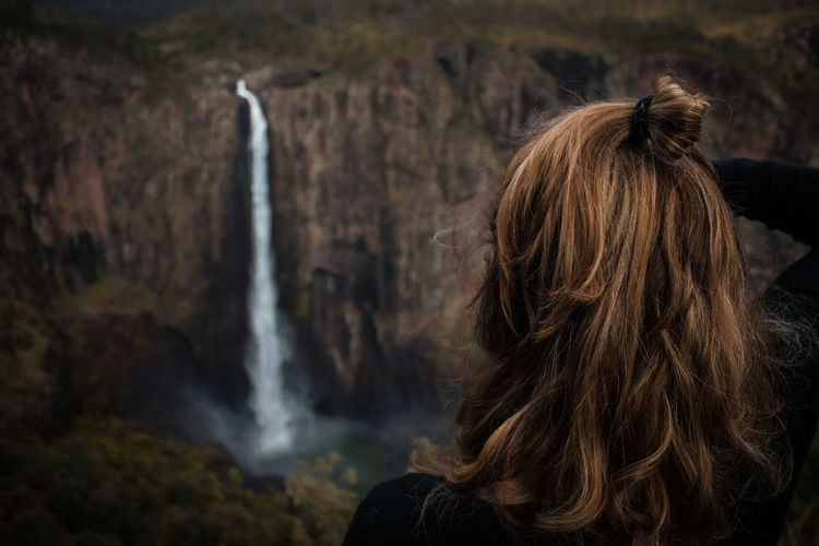 Rear view of woman looking at waterfall