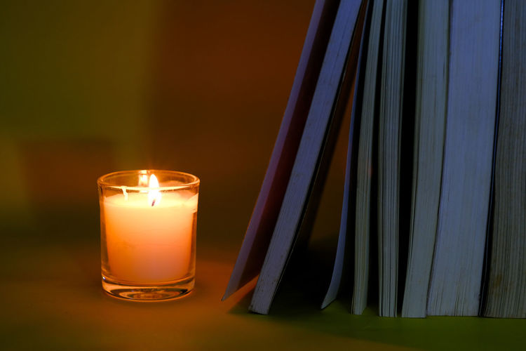 Close-up of illuminated candles in glass