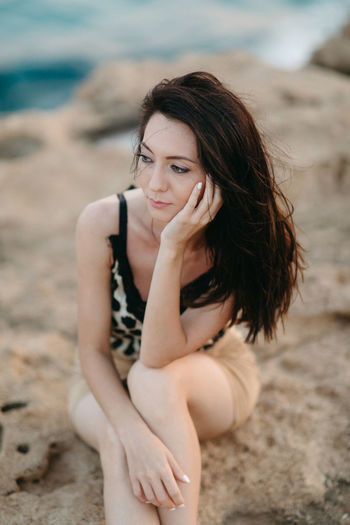 Portrait of beautiful model sitting on beach