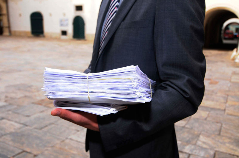 Man in suit with files and paperwork in the administration
