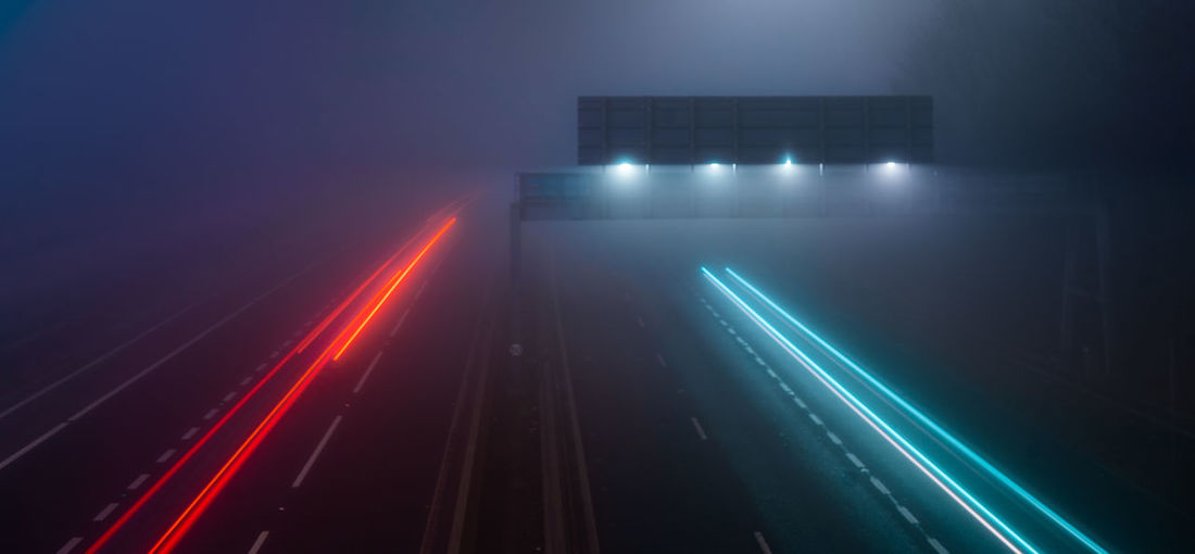 High angle view of light trails on illuminated city at night
