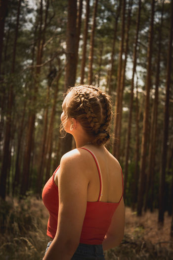Rear view of woman standing in forest