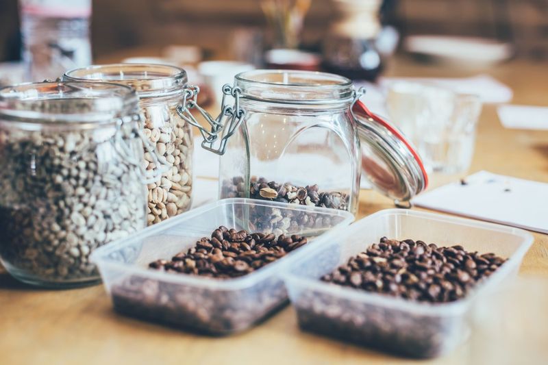 Roasted coffee beans in containers on table