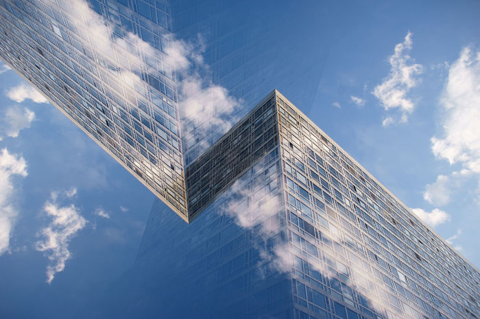 LOW ANGLE VIEW OF GLASS BUILDING AGAINST SKY