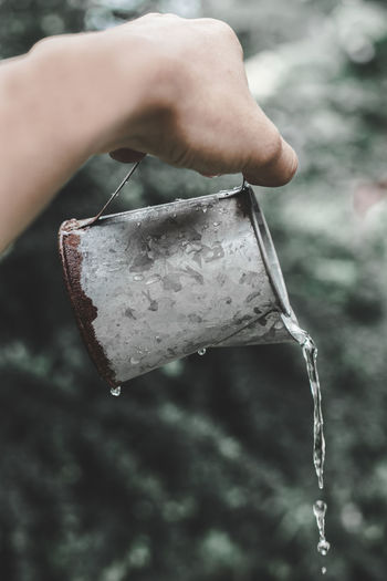 Cropped hand pouring water from can
