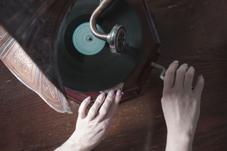 Woman hands turn the handle of an old gramophone,horrible halloween holiday