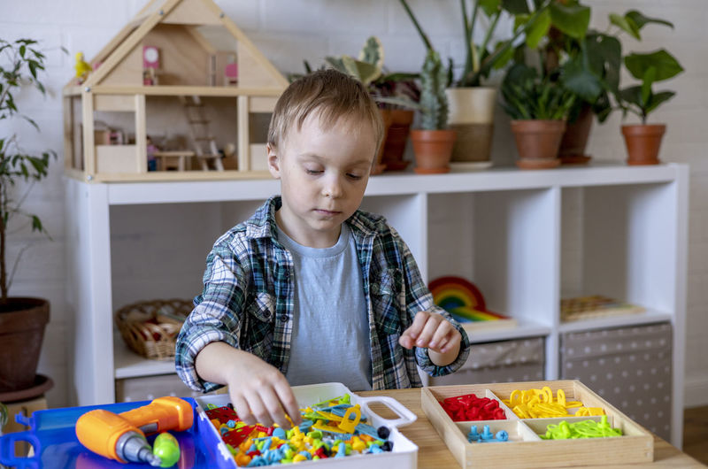 Boy playing with plastic toys at home