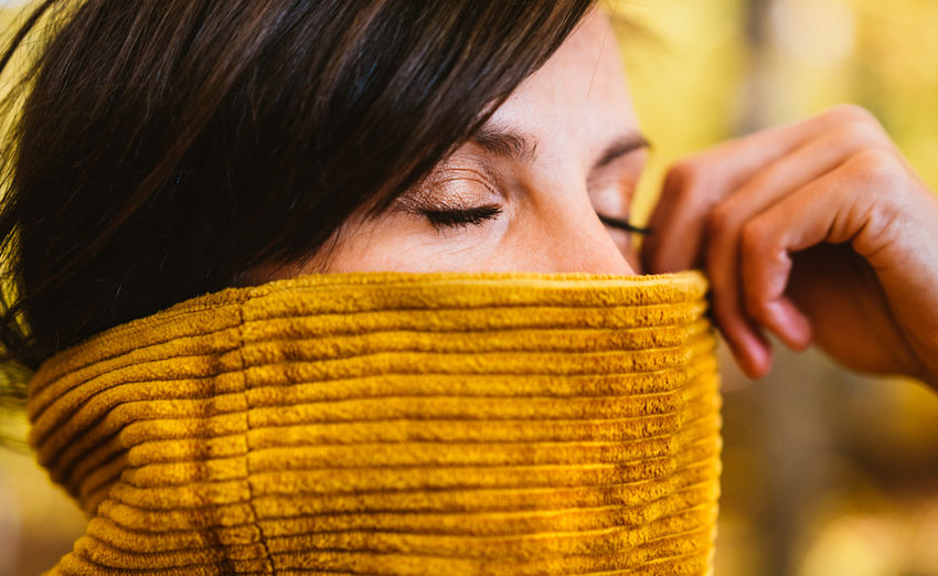 Close-up of woman face covered with sweater