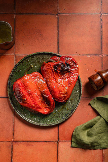 From above of appetizing roasted red pepper served on ceramic plate with oil on tilled surface