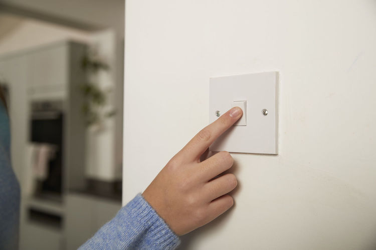 Finger of girl turning off switch at home