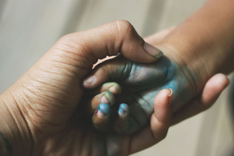 Cropped image of person holding messy hand on child