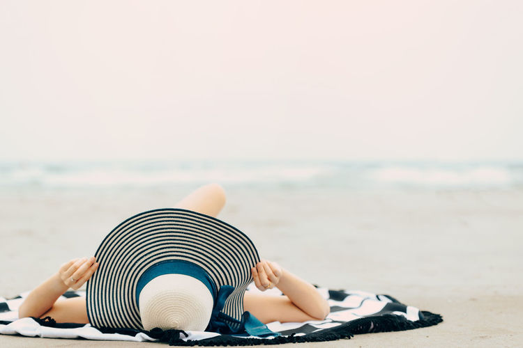 Close-up of child on beach against clear sky