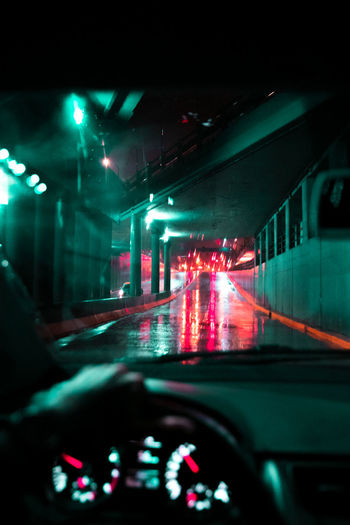Cars on illuminated street seen through car windshield