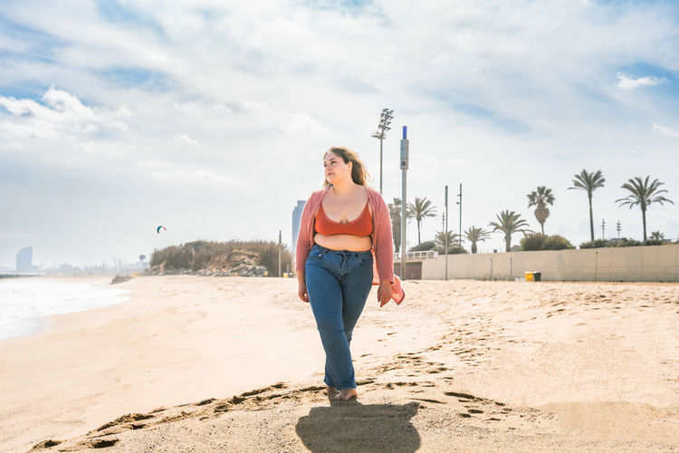 Woman walking on beach on sunny day