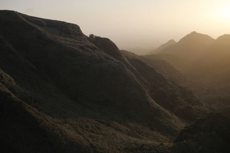 Scenic view of mountains against clear sky during sunset