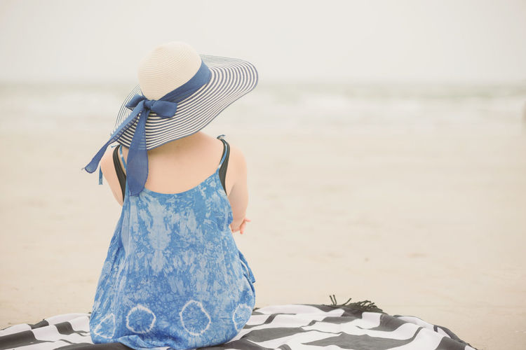 Rear view of woman wearing hat on beach
