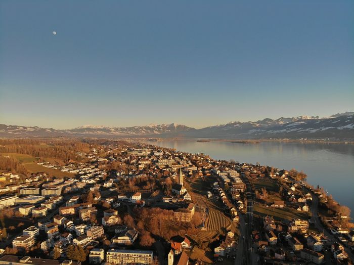 Aerial view of lake and mountains against clear blue sky
