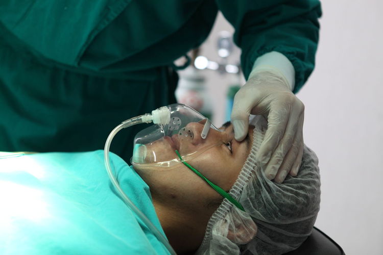 Midsection of doctor examining patient eye in hospital