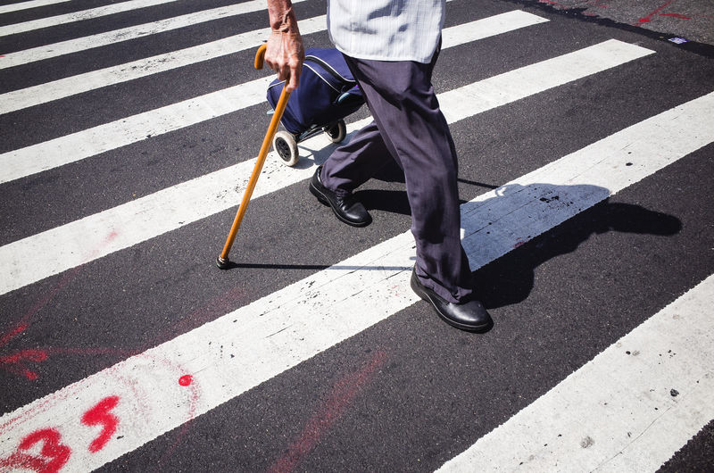 Low section of man crossing road