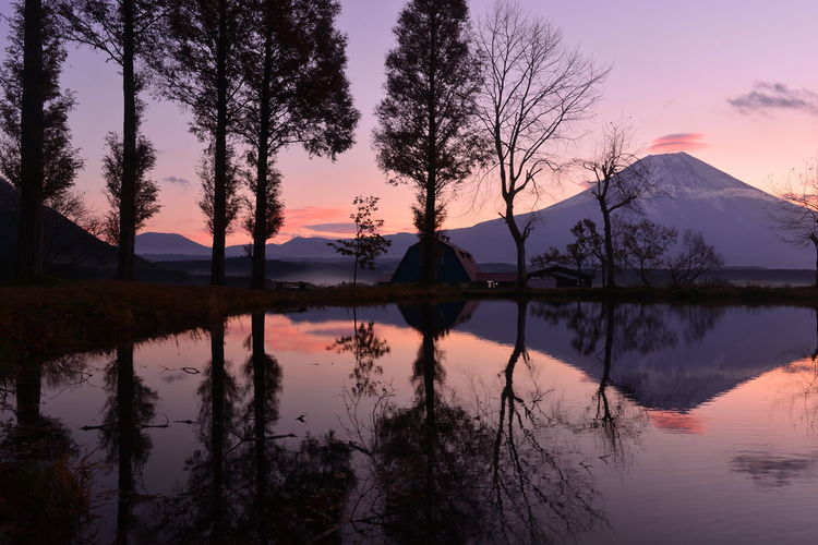 Tranquil view of trees and mountain reflected in lake