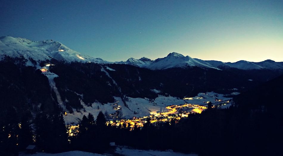 Scenic view of snow covered mountains against clear sky at dusk