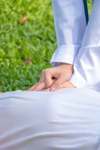 Close-up of doctor giving cpr to patient lying on field 