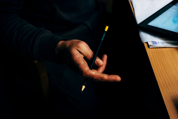 Close-up of man holding pencil