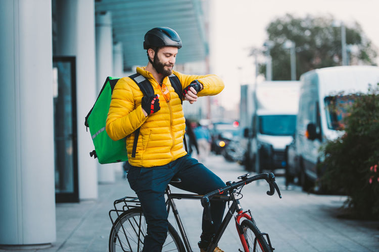 Smiling man sitting on bicycle on street