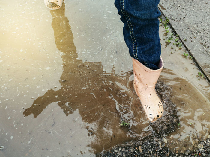 Low section of person walking in puddle