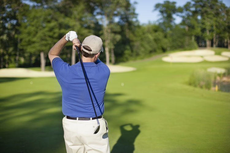 Rear view of man playing golf