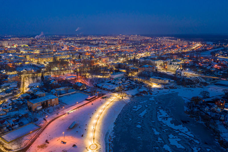 Beautiful evening top view of the city. winter city in the snow. the river is covered with ice.