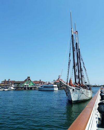 Sailboats in sea against clear blue sky