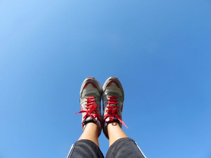 Low section of person against clear blue sky