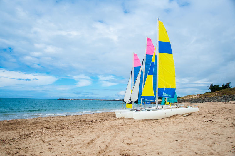 Sailing boats waiting on the beach in summer before starting a sailing lesson