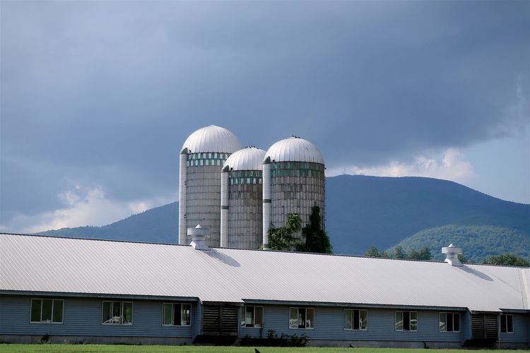 Farm and silos with mountains in the background