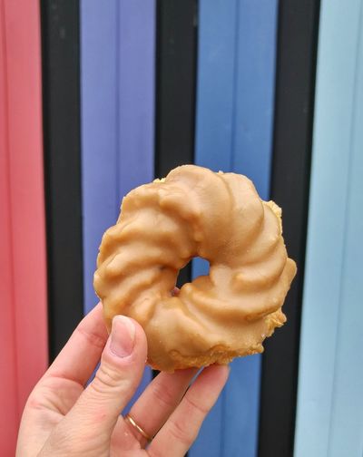 Cropped image of hand holding donut 