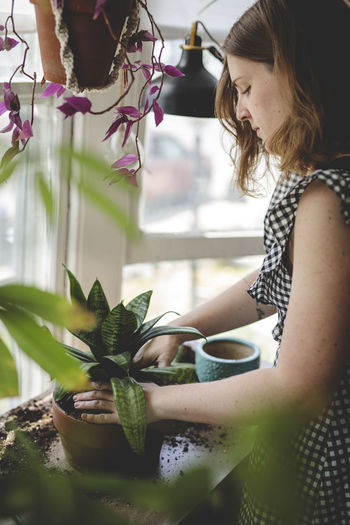 Woman looking at potted plant