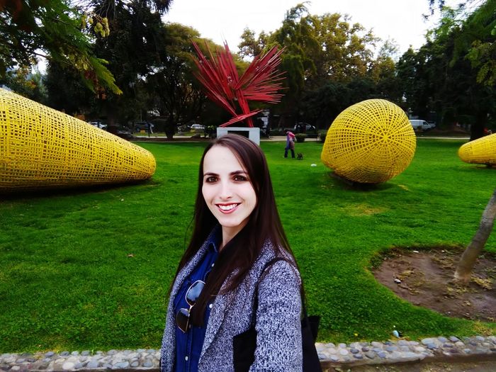 Portrait of smiling young woman standing in park