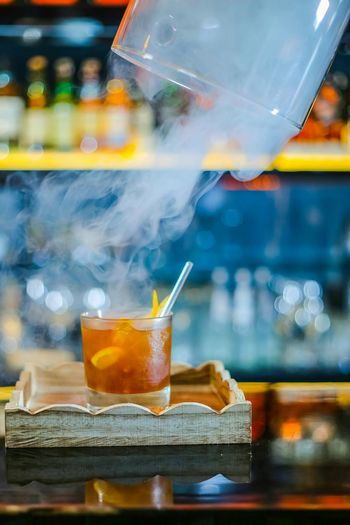 Smoke emitting from cocktail on table
