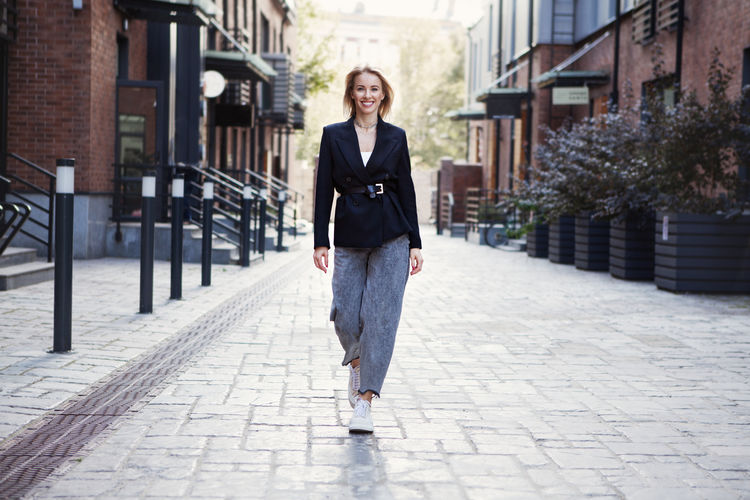 Portrait of smiling businesswoman walking on street