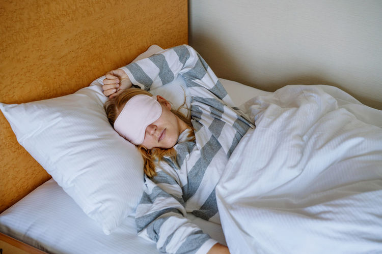 Woman sleeping in bed with the eye mask